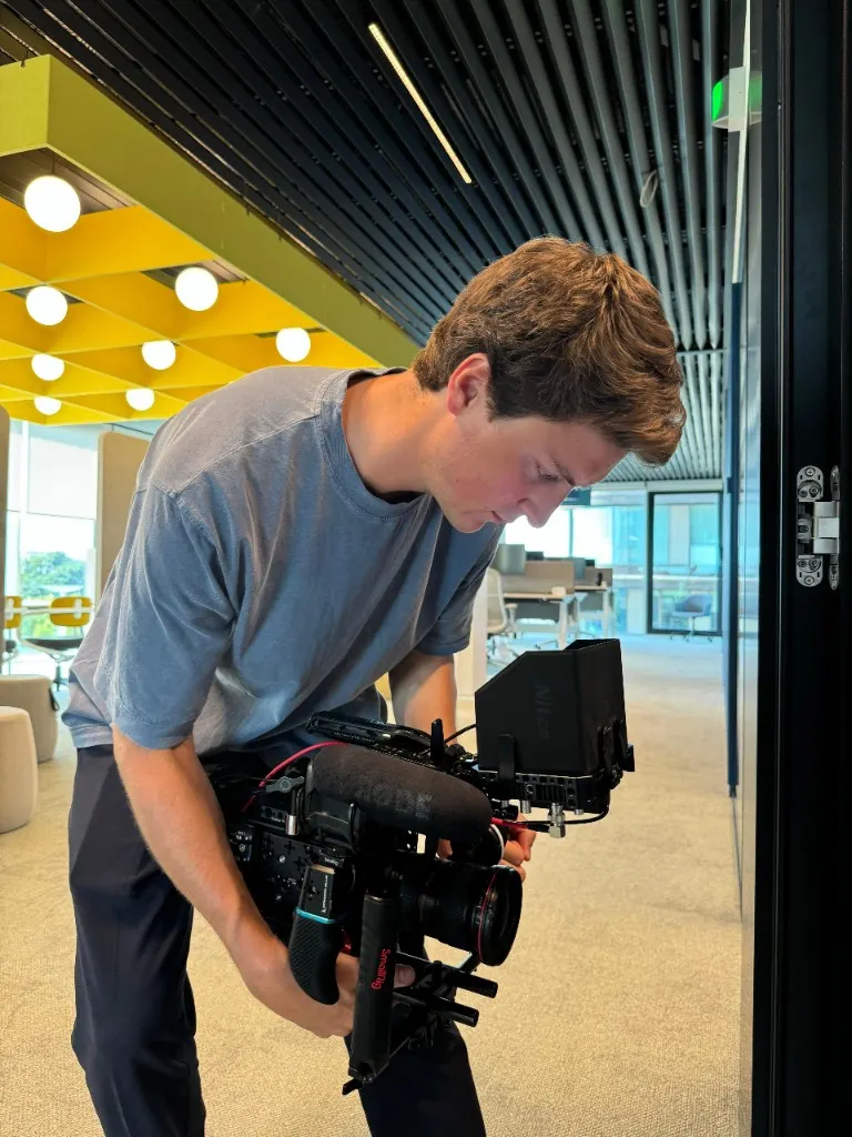 Antoine Similon operating a handheld camera rig in a modern office